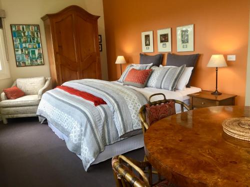 a bedroom with a large bed and a table at Llarrinda Bed & Breakfast in Foster