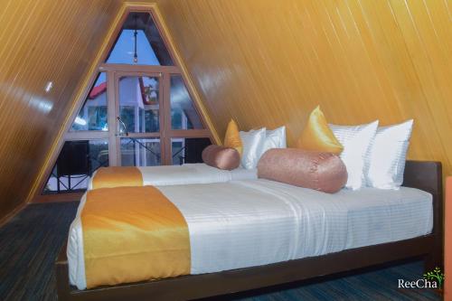 two beds in a room with a window at Reecha Organic Resort Jaffna in Kilinochchi