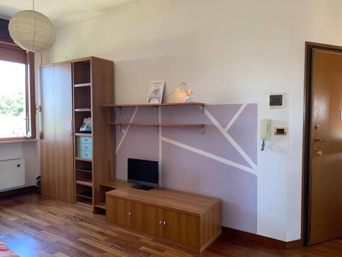 sala de estar con TV y estante de libros en Un Tetto Sulle Nuvole by SMART-HOME, en Tagliolo Monferrato