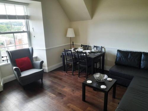 sala de estar con sofá, mesa y sillas en Kirkcudbright Holiday Apartments - Apartment F, en Kirkcudbright