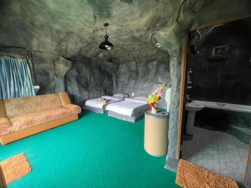 a room with a bed and a couch in a cave at สวนป่าภูนับดาว รีสอร์ท เขาค้อ in Ban Khao Ya Nua