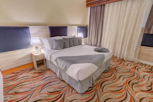 a hotel room with a large bed and a carpet at Hayah Plaza Hotel in Medina