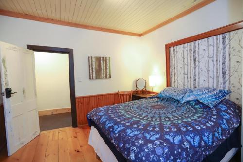 a bedroom with a blue bed and a window at 23Maple in Haliburton