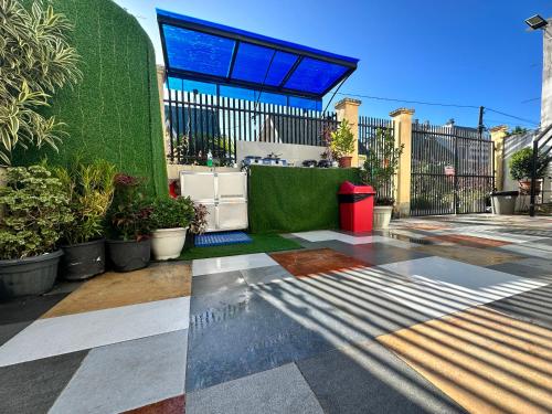 a patio with a green wall and plants and a red trash can at Tacloban EVMC Gdex Transient House in Tacloban