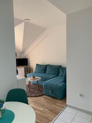 un soggiorno con divano blu e tavolo di Filip Apartment a Mavrovo