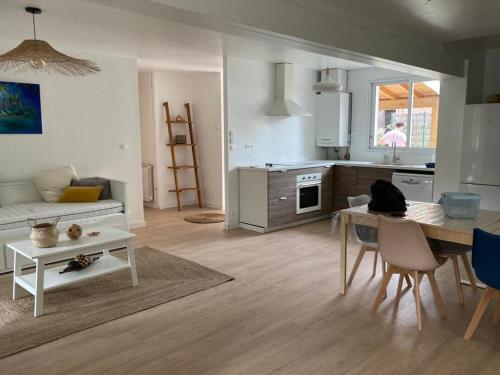 une cuisine et un salon avec une table et un canapé dans l'établissement La Canaulaise, à Lacanau