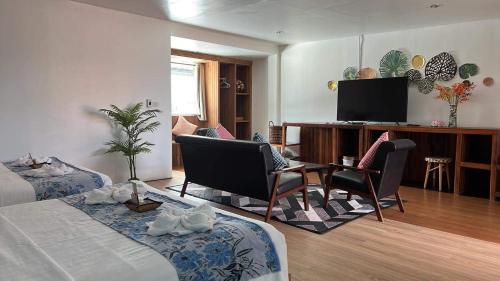 a hotel room with two beds and a flat screen tv at Varni Homestay in Phatthalung