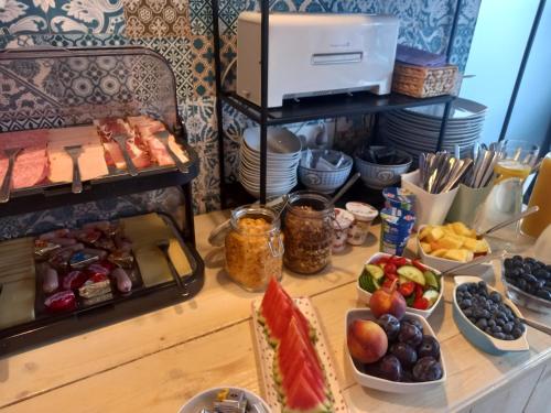 a table topped with plates of food and bowls of fruit at Pension Villa Louise in Sankt Kanzian