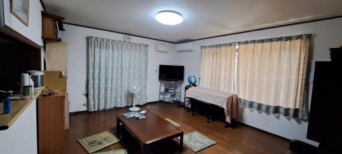 a living room with a table and a living room with a table at Shino's Farm Inn in Azumino