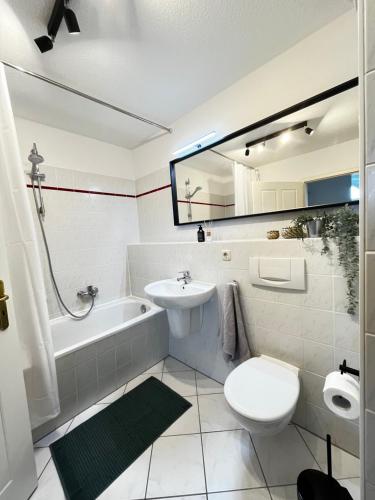 a bathroom with a sink and a toilet and a bath tub at MOKA Living-Sunset Apt, Nordic Design,Küche,WLAN, SmartTV in Magdeburg