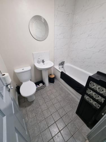 een witte badkamer met een toilet en een wastafel bij Donard View Apartment in Newcastle