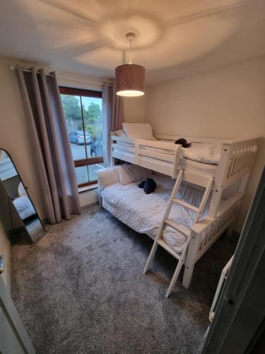een slaapkamer met twee stapelbedden en een raam bij Donard View Apartment in Newcastle