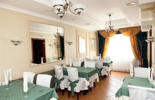 uma sala de jantar com mesas verdes e brancas e um espelho em Atlantik Hotel em Vyborg