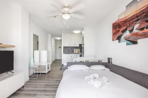 una camera da letto bianca con un letto e una cucina di Garden City Pool and Sea view by LoveTene a Playa Fañabe