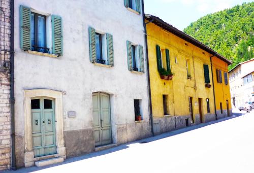 a building with green and yellow doors on a street at Camera con vista in Fossombrone