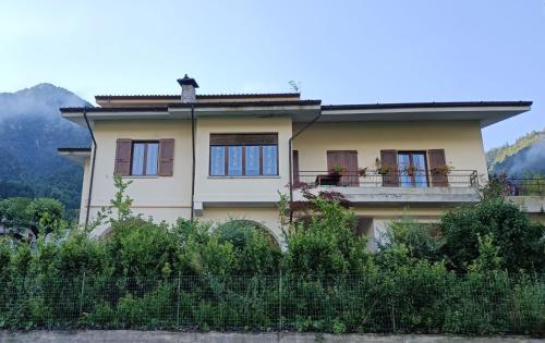 une maison avec un balcon et des montagnes en arrière-plan dans l'établissement B&B le rose, à Crone