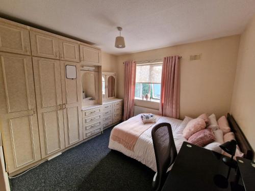 ein Schlafzimmer mit einem Bett, einer Kommode und einem Fenster in der Unterkunft Females Only - Private Bedrooms in Dublin in Lucan