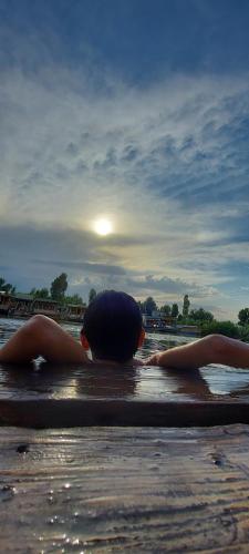 a person laying in the water on the beach at Green view group of houseboats in Srinagar