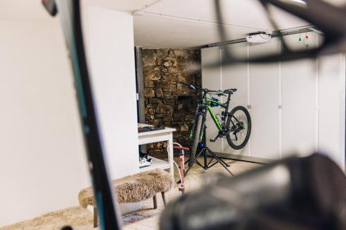 a bike parked in a room with a wall at Amplatz 1523 - B&B and Suites in Montagna