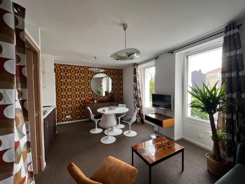 ein Wohnzimmer mit einem Tisch und einem TV in der Unterkunft Appartement - Galerie POP ART - Trentemoult in Rezé