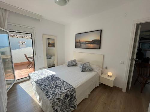 a bedroom with a bed and a view of the ocean at Apartamento en acantilado con wifi y aire acondicionado in Sitges