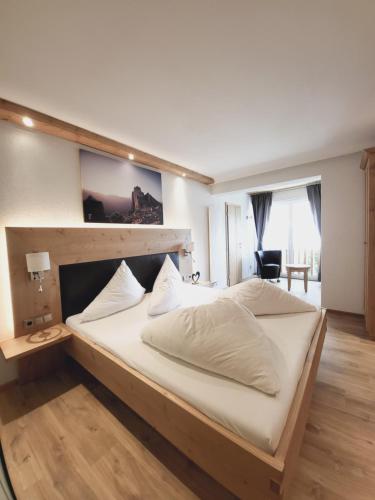 a bedroom with a large bed with a wooden headboard at Adler Hotel-Pension in Fulpmes