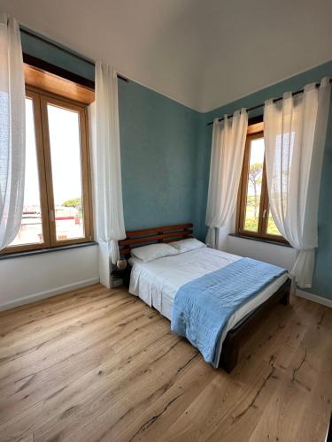 una camera con un letto e due finestre di Villa Mazza al Vesuvio a Torre del Greco