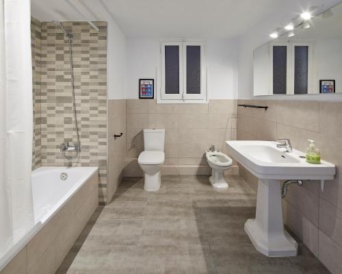 een badkamer met een wastafel, een toilet en een bad bij GIRONA in Barcelona