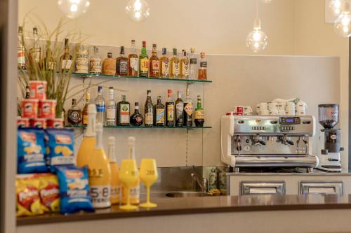 a kitchen counter with a sink and bottles of alcohol at Hotel Stella Del Mare in Cervia
