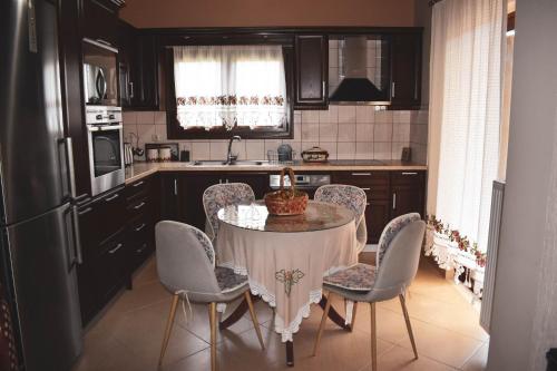 een keuken met een tafel met stoelen en een wastafel bij Rose Garden Villa 