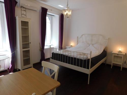 Habitación pequeña con cama, mesa y sidra de mesa en Apartment Keymaster's Hideaway, en Liubliana