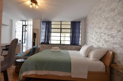 - une chambre avec un lit et un mur en briques dans l'établissement Studio Mavili, à Athènes
