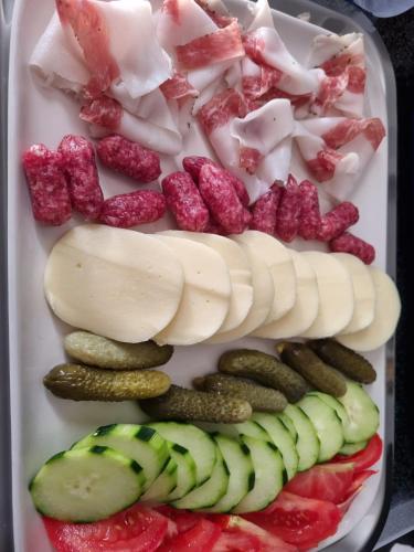 a tray of food with cheese and vegetables on it at Crystal B&B in Dormelletto