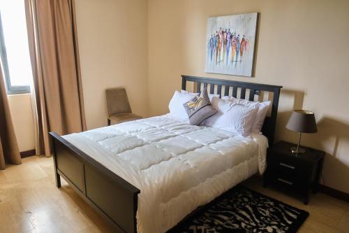 a bedroom with a large bed with white sheets and pillows at 22 Premier Place in Accra