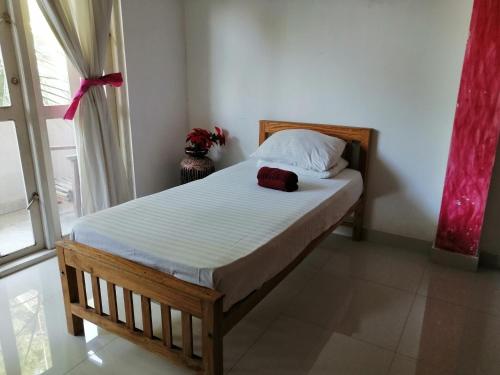 a small bed in a room with a window at Sithila Villa in Mount Lavinia