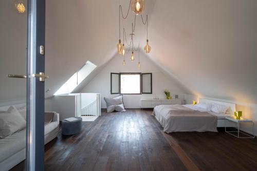 - une chambre blanche avec un lit et un escalier dans l'établissement Weinkeller Röschitz, à Roggendorf