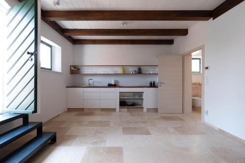 a kitchen with white walls and wooden ceilings at Weinkeller Röschitz in Roggendorf