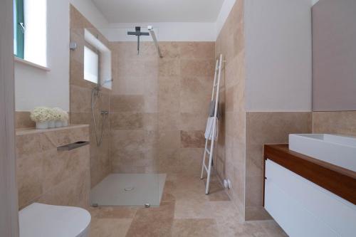 La salle de bains est pourvue d'une douche, de toilettes et d'un lavabo. dans l'établissement Weinkeller Röschitz, à Roggendorf