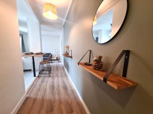 a hallway with a mirror on the wall and a table at Appartement F3 55m2 à 5' de Paris in Ivry-sur-Seine