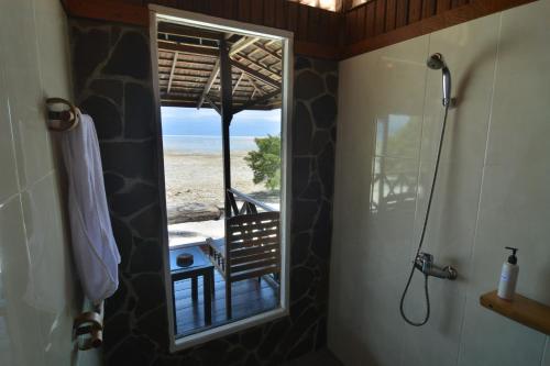 a bathroom with a shower with a view of the beach at Nunukan Island Resort in Maratua Atoll