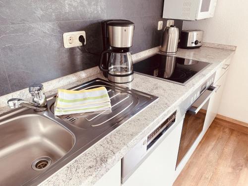 a kitchen with a sink and a coffee maker on a counter at Ruhig, modern & Nähe Altstadt! in Meiningen