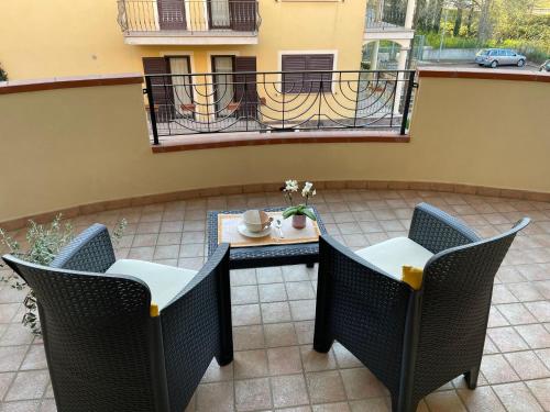 patio con mesa y sillas y balcón en Appartamento Sa Benda, en Nuoro
