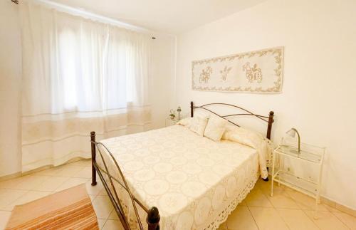 Appartamento Sa Benda في نوورو: غرفة نوم بيضاء بها سرير ونافذة