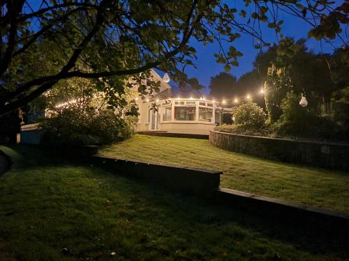 a white house with lights on a yard at night at Gap Retreat in Carrickmore