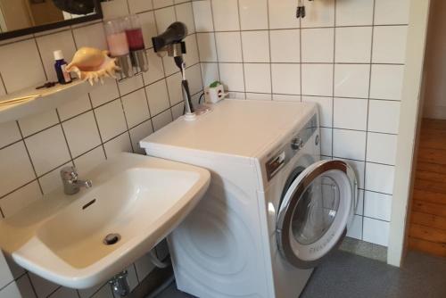 a bathroom with a washing machine and a sink at Private Apartment in Hannover