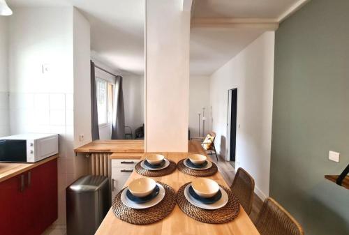 a kitchen with a wooden table with hats on it at Appartement F3 55m2 à 5' de Paris in Ivry-sur-Seine