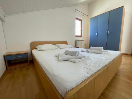 a large white bed with towels on top of it at Apartments Hanka in Njivice