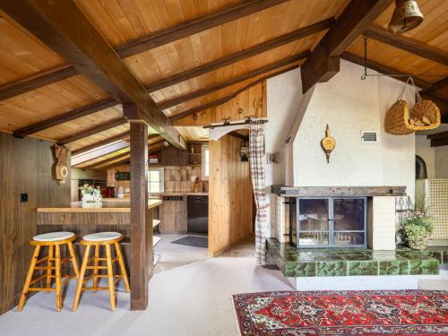 a kitchen with a fireplace and wooden ceilings at Chalet am Sunne-Egge auf Axalp bei Brienz in Axalp