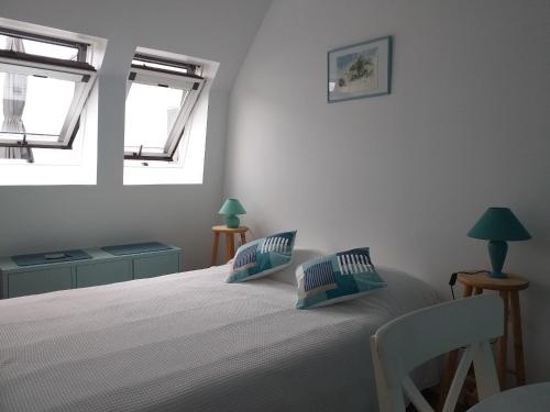 une chambre avec un grand lit avec deux fenêtres dans l'établissement Sur les toits d'Orléans, à Orléans