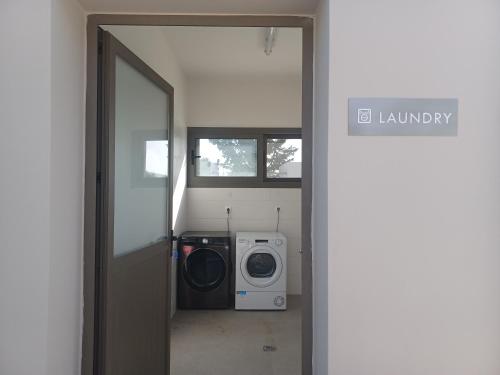 a door to a laundry room with a washing machine at Nirikos Camping in Spasméni Vrísi